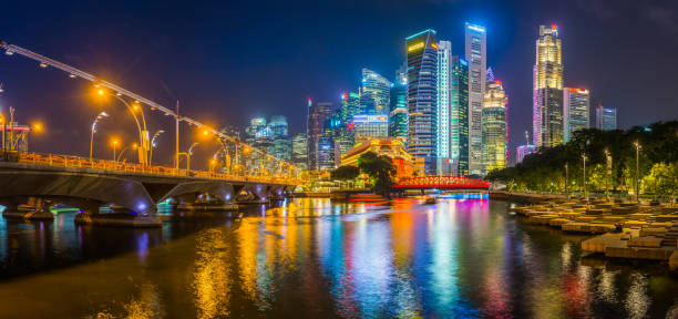 arranha-céus de néon da noite de singapore que brilham sobre panorama das pontes do rio de singapore - singapore skyline - fotografias e filmes do acervo