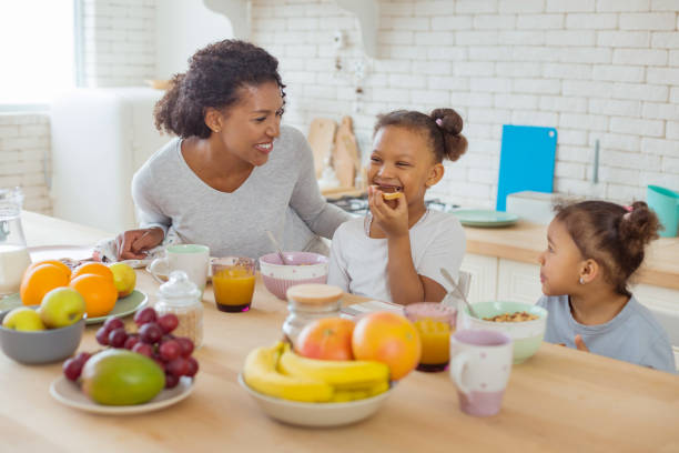istock Cheerful young woman looking at her daughters 1136159612