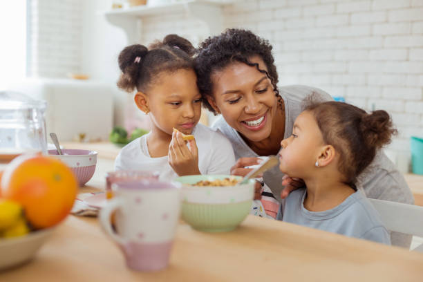 istock Beautiful dark-skinned female person feeding her kid 1136159621