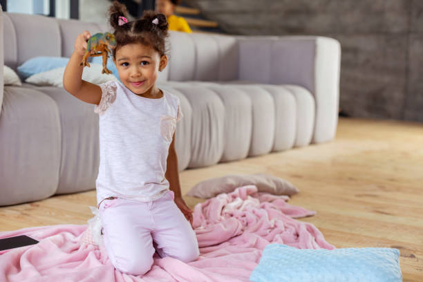 istock Charming brunette little girl showing her dinosaur 1136161661