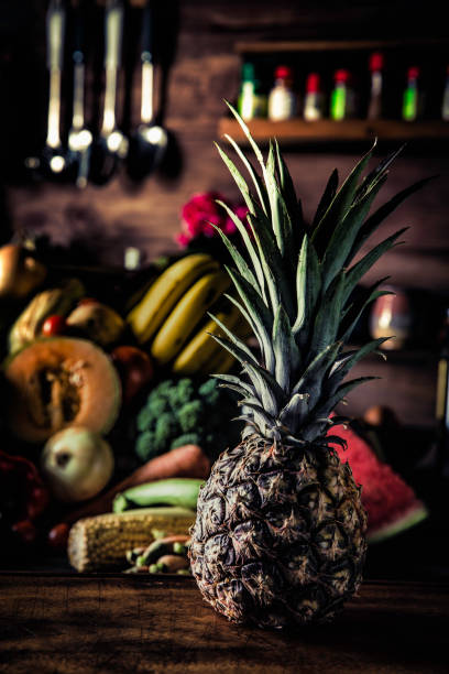 istock Pineapple with organic tropical fruits and vegetables in old fashioned rustic kitchen 1136164677