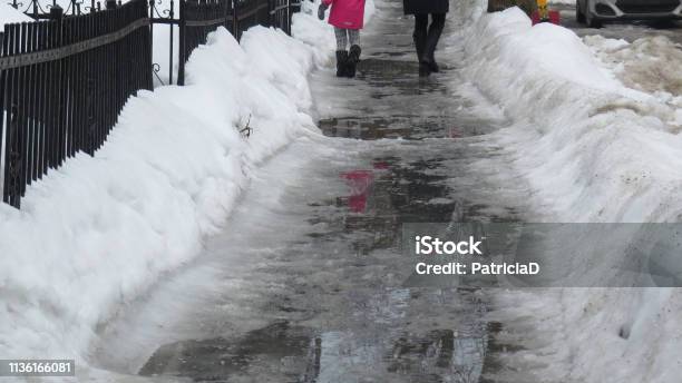 Mother And Daughter Walking On Slushy Slippery Sidewalk In Montreal Stock Photo - Download Image Now