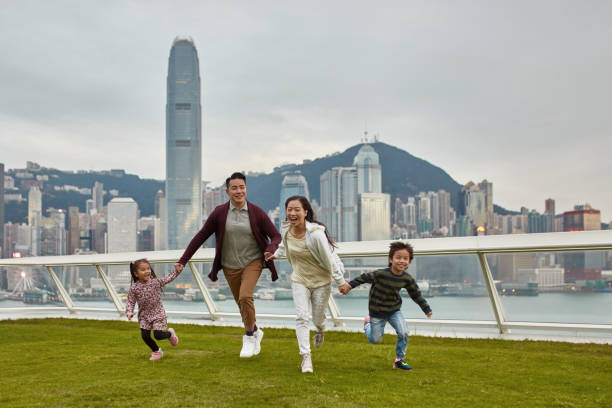 istock Family holding hands running on grass at park 1136167402
