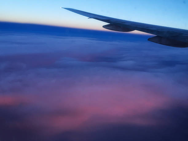 istock wing of an airplane going over the clouds at sunset 1136169641
