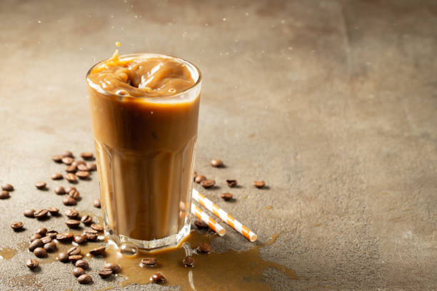 istock Iced latte coffee splash with ice cubes and roasted beans on a dark background. With copy space 1136170646