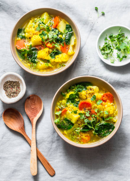 istock Yellow lentils and vegetables potatoes, carrots, cauliflower, turnips and turmeric thick vegetarian soup on a light background, top view. Healthy food concept 1136174740