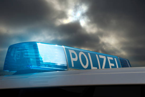 german police car with siren against a cloudy sky