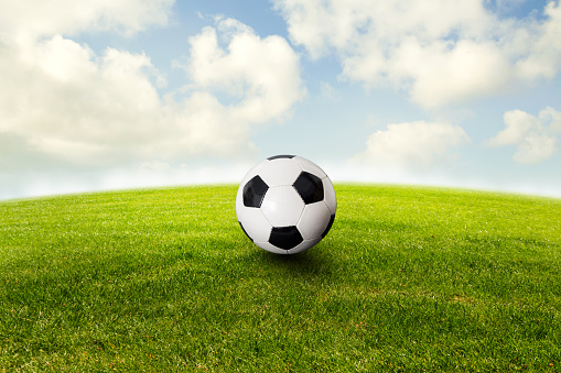 soccer ball on the green against a blue sunny sky
