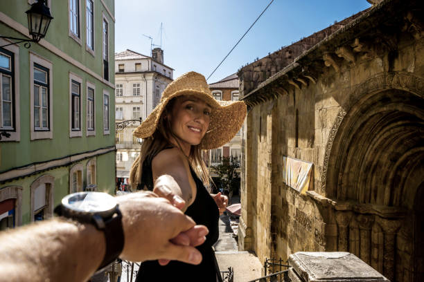 Canadian Woman holding her husband’s hand in Coimbra Canadian woman visiting her home country through the old streets and different styled buildings of the ancient Portuguese capital city, Coimbra. coimbra city stock pictures, royalty-free photos & images