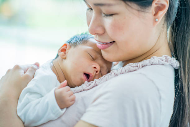 istock Baby boy sleeps in mom's arms 1136179192