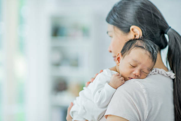 istock Mother holds sleeping baby 1136179195