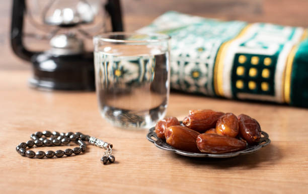 wasser und datteln. iftar ist das abendessen. blick auf die dekoration ramadan kareem ferienteppich-hintergrund - fasten stock-fotos und bilder