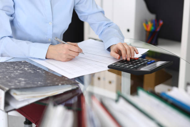 istock Unknown bookkeeper woman or financial inspector  making report, calculating or checking balance, close-up. Business portrait. Audit or tax concepts. 1136181246
