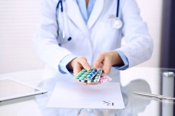 istock Unknown doctor hands holding pack of different tablet blisters closeup. Life save service, legal drug store, prescribe medication, disease healing concept. 1136181267