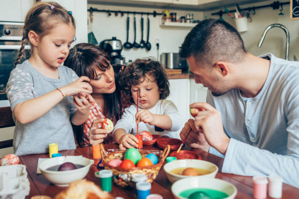 istock Happy family coloring Easter eggs 1136185625