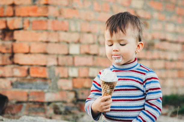 istock little cute boy boy boy three years eating ice cream very appetizing on brick wall background 1136186361