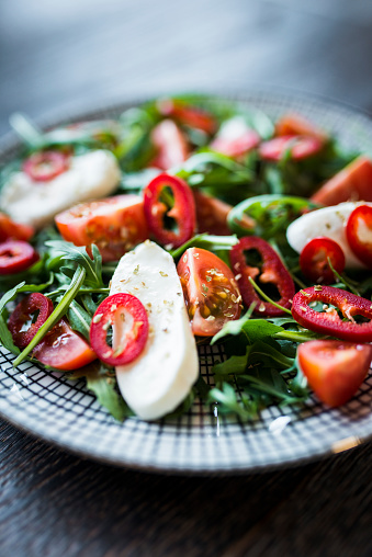 Closeup of a Caprese Salad on Wooden Table - foreground focus