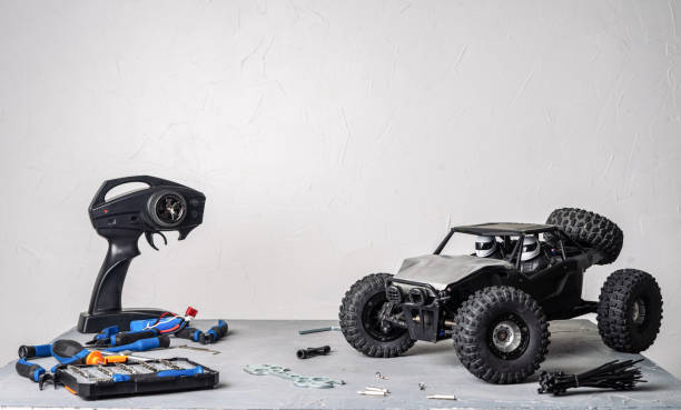 istock Radio-controlled car models: a table with scattered tools for repairing rc buggy models and a control panel. 1136187352