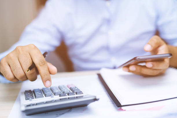 istock Close up young woman hand is writing in a notebook and using calculator counting making notes Accounting at doing finance at home office.  Savings finances concept. note pad 1136188122