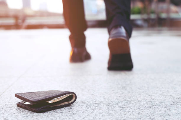 businessman had lost leather wallet with money on the street. Close-up of wallet lying on the sidewalk in during the trip to work. stock photo