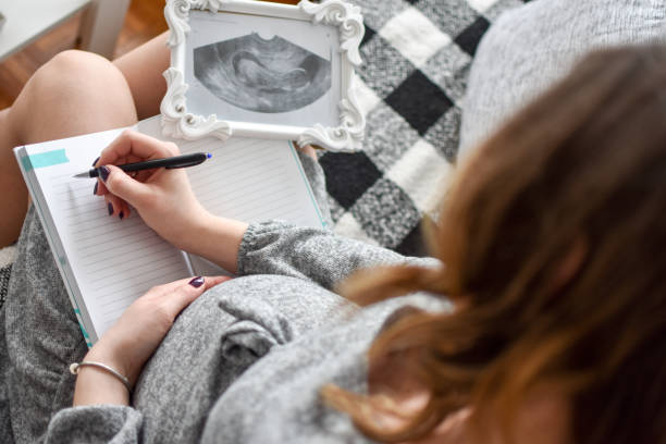 kobieta w ciąży pisze imiona dla swojego dziecka - writing instrument handwriting document note zdjęcia i obrazy z banku zdjęć