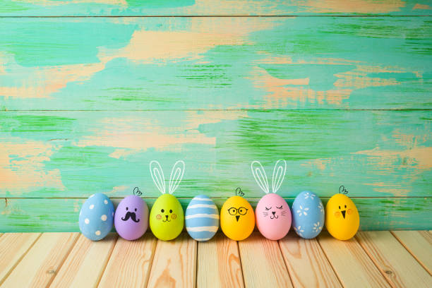 decorazioni di uova di pasqua su tavolo di legno su sfondo colorato - funny eggs foto e immagini stock