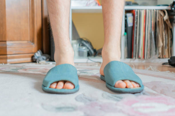 Man feet at home in pajamas and winter slippers