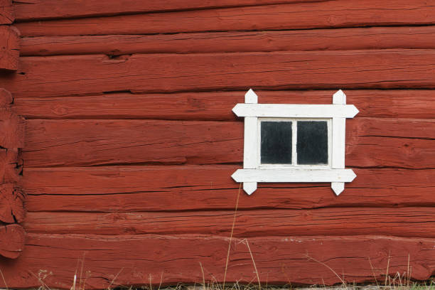 istock Old Wooden red log wall with small window, traditional in Scandinavia. 1136193228