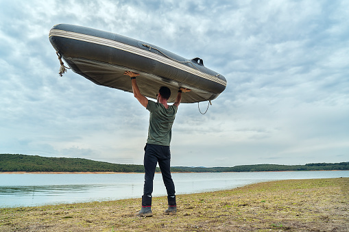 Man carrying a boat to lake