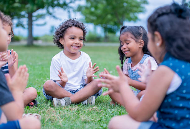 istock Children sitting on the grass in a park 1136196345