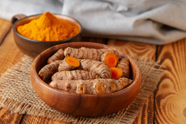 istock Turmeric roots and powder on wooden background 1136198391
