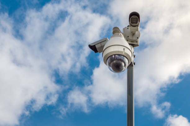 istock CCTV security cameras on pole on blue sky with white clouds background 1136198555