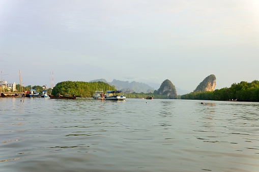 The Khao Khanap Nam limestone mountains on the Krabi river with the marina and tour boats in Thailand