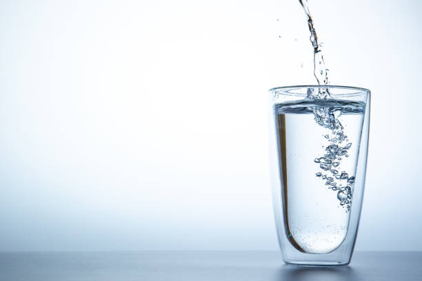 plonger l'eau dans un double verre près. - glass cup photos et images de collection