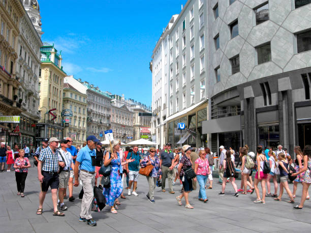 Austria, Vienna. Downtown of the city crowded of people. Group of tourists with guide on pedestrian tour.
