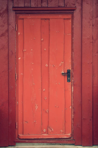 istock Old wooden red rustic cabin door with antique handle. Norway. 1136205267