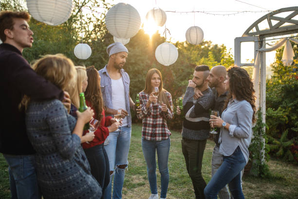 istock Young group of people enjoying drinks at a party 1136205330