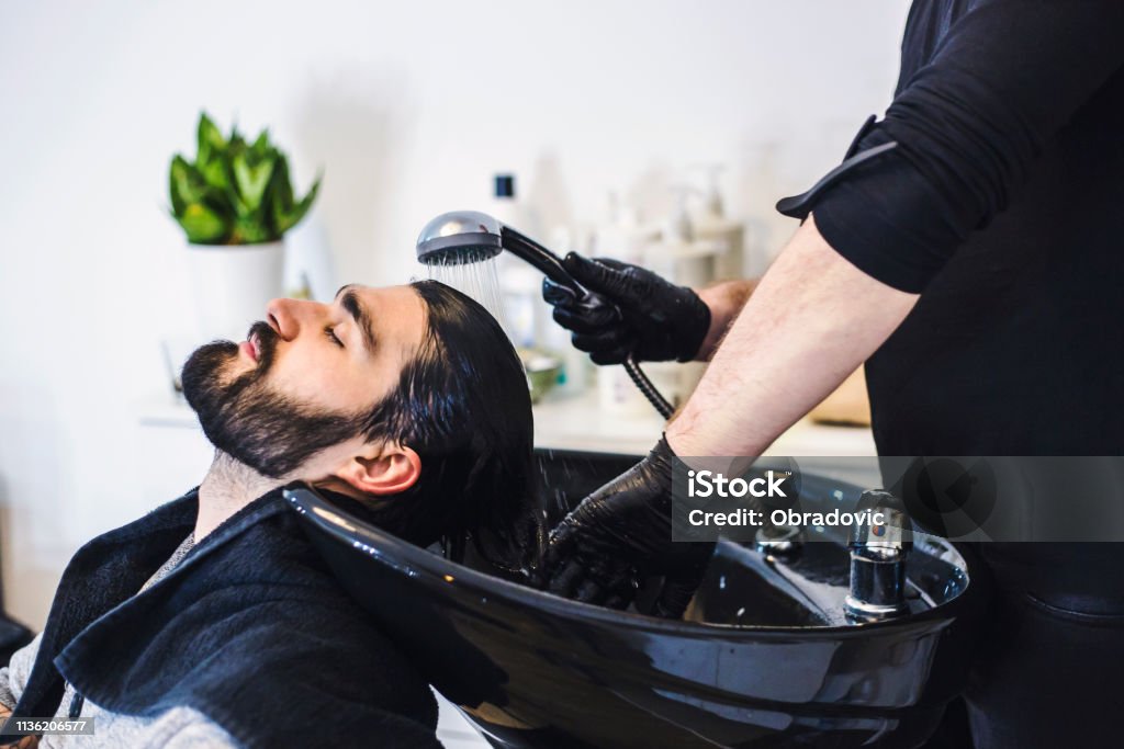 Man getting hair washed at hairdresser Barber Shop Stock Photo