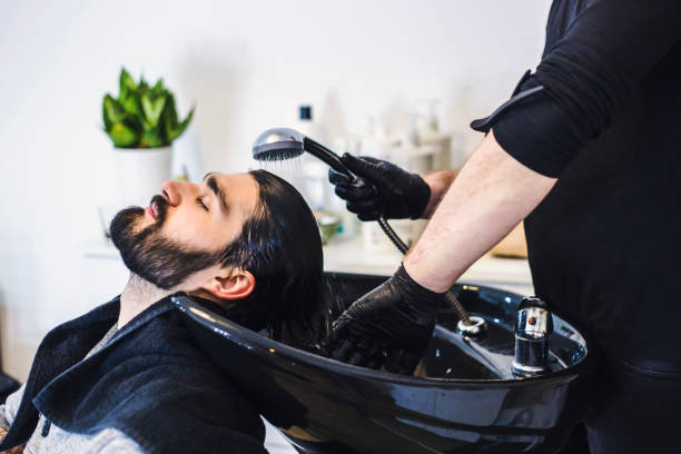 Man getting hair washed at hairdresser stock photo