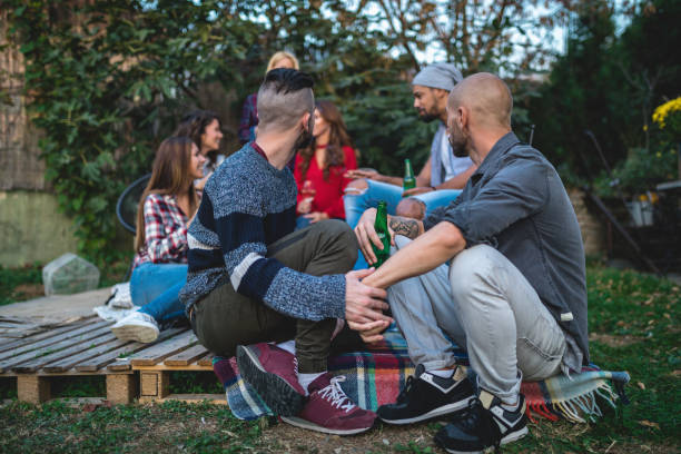 istock Homosexual couple holding hands while having fun with friends at a party 1136206890