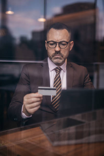 istock Elegant senior man with eyeglasses using credit card 1136207183