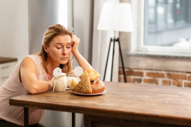 istock Woman feeling hungry looking at bread and buns but having allergy 1136208247