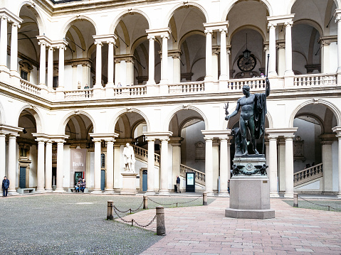 Milan, Italy - February  24, 2019: visitors in Cortile d'Onore courtyard of Palazzo Brera, house of Pinacoteca di Brera (Brera Art Gallery) in Milan city, Lombardy