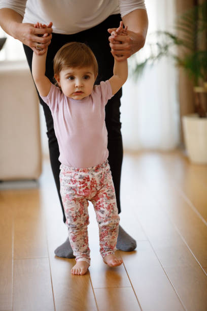 istock Mother learning her baby girl to walk 1136215498