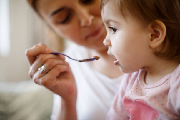 madre alimentando a su bebé - baby food fotografías e imágenes de stock