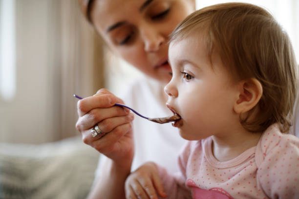 istock Mother feeding her baby at home 1136215588