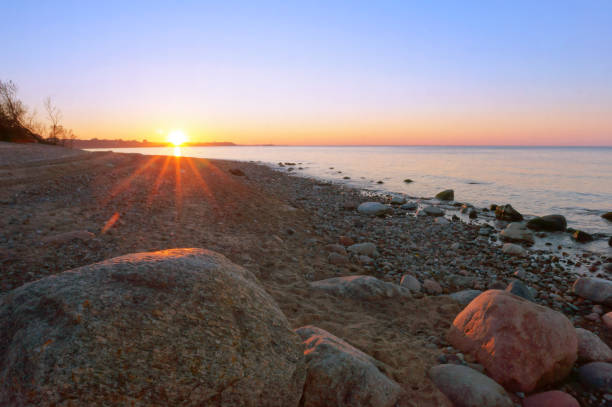 istock , sunset on the rocky seashore, huge stone boulder on the sea 1136215962