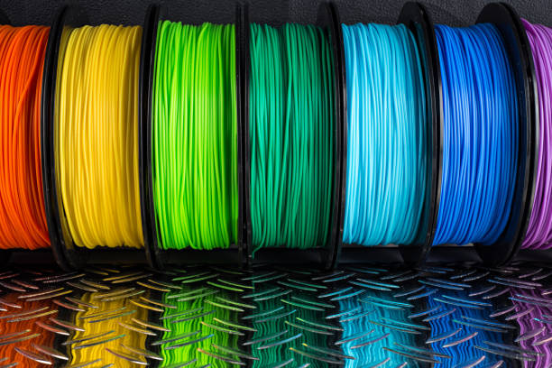 colorful bright  row of spool 3d printer filament black metal background colorful bright row of spool 3d printer pla abs filament plastic material on dark black metal steel diamond plate background light bulb filament photos stock pictures, royalty-free photos & images