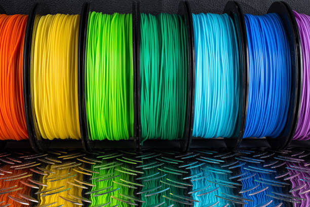 colorful bright row of spool 3d printer filament black metal background colorful bright row of spool 3d printer pla abs filament plastic material on dark black metal steel diamond plate background 3d printing lab stock pictures, royalty-free photos & images