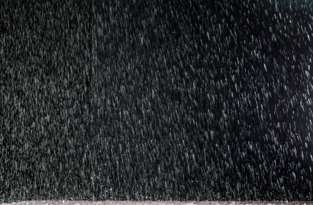 istock Night rain flows with splashes on the surface of the puddle. 1136216896